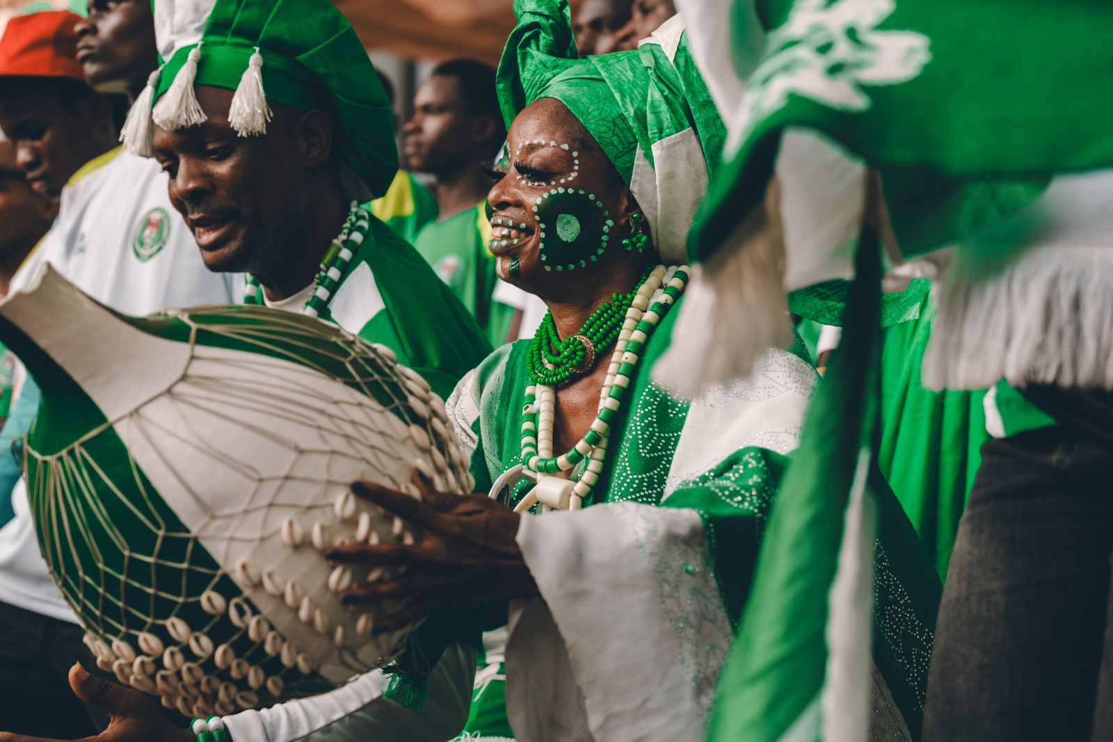 Scène vibrante de batteurs africains en tenue traditionnelle, animant une joyeuse célébration culturelle.